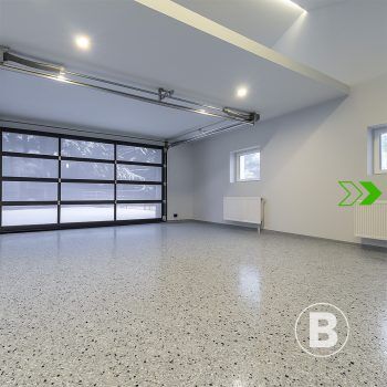 Bright garage with modern finish alt="Bright garage with grey flake floor coating."