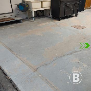 Worn garage floor alt="Worn and stained concrete garage floor."
