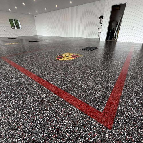 alt="residential garage with polyaspartic floor and logos in them"