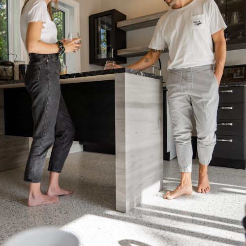 alt="two person standing barefoot on a radiant kitchen floor made of polyaspartic"
